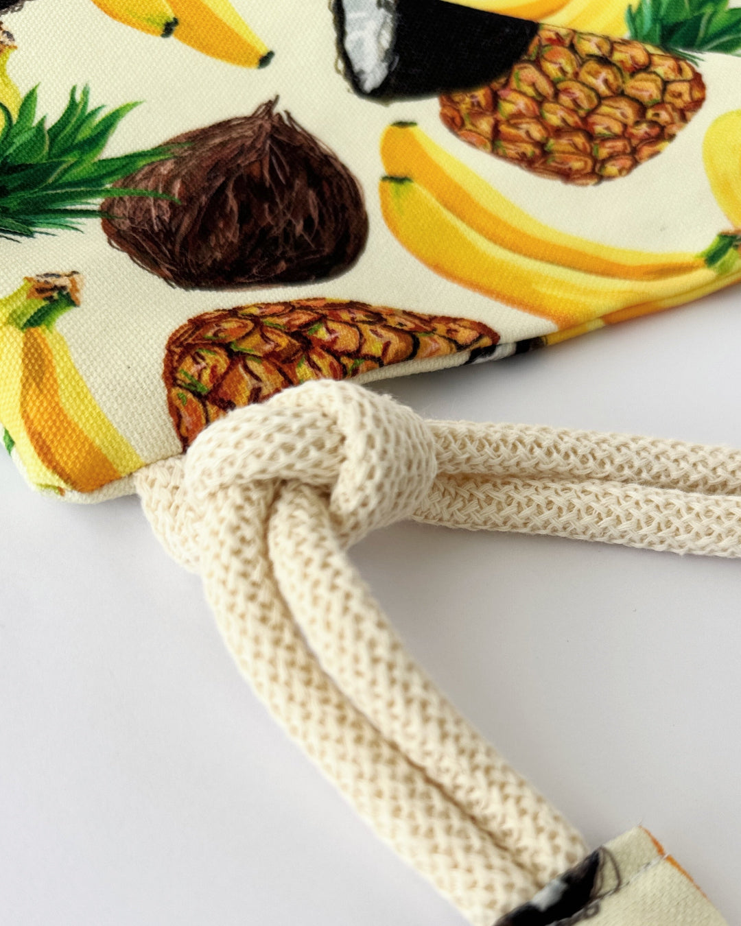 Handmade macramé backpack with soft cream macramé top and tropical fruit print canvas bottom in beige tones – Tropica Zanzibar design.