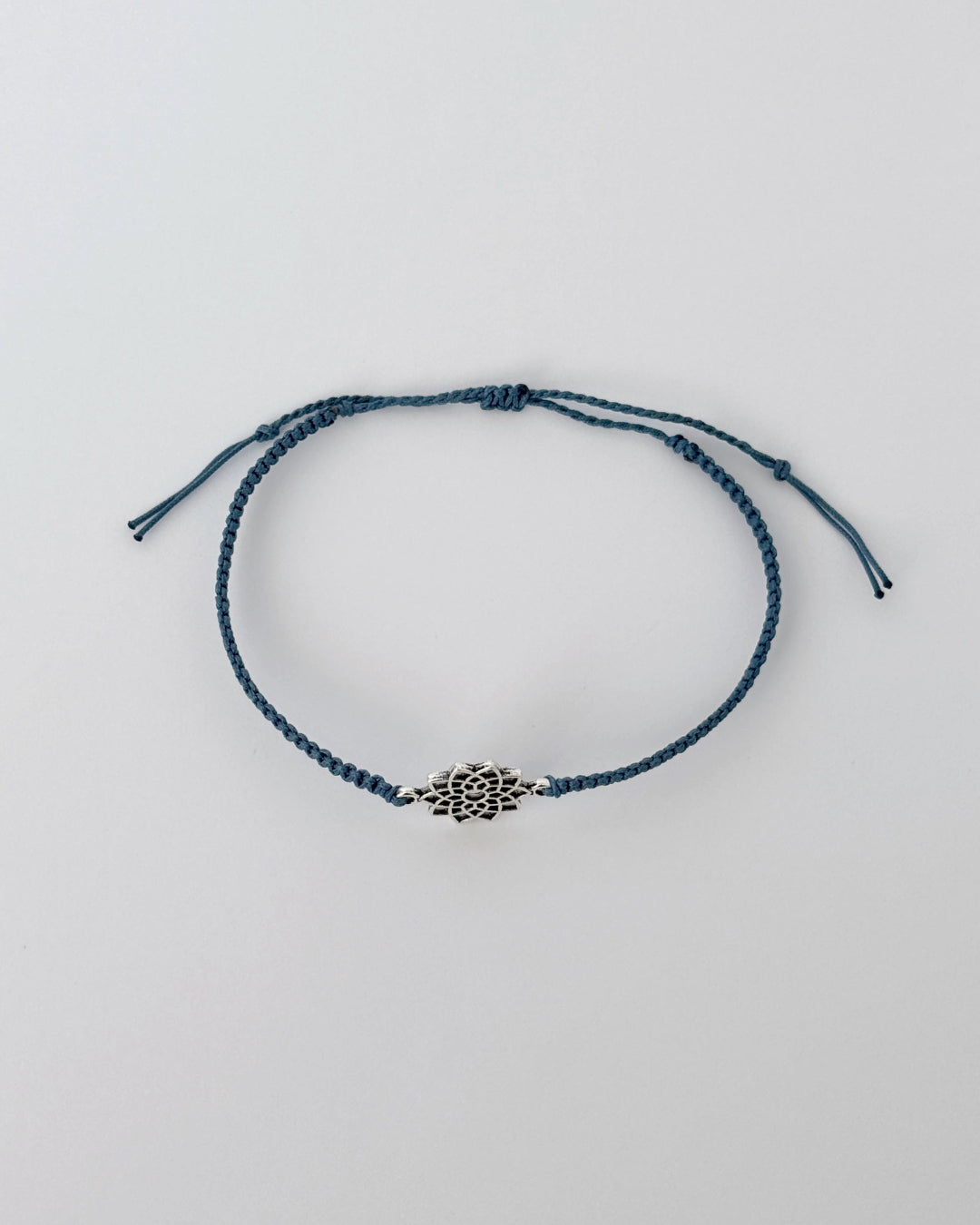 צמיד Lotus הוא צמיד חוט בעבודת יד בגוון כחול-ים עמוק, המשלב תליון פרח לוטוס בצבע כסף. העיצוב שואב השראה מסמלים של התחדשות ושלווה, אך מביא אותם בפרשנות מינימליסטית, עכשווית ומדויקת.