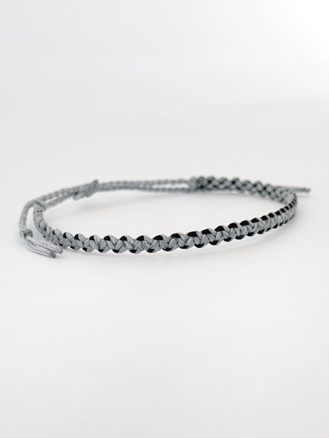 צמיד חוט לגבר Wave בעבודת יד בגווני אפור-תכלת ושחור, בעיצוב מינימליסטי ונקי.