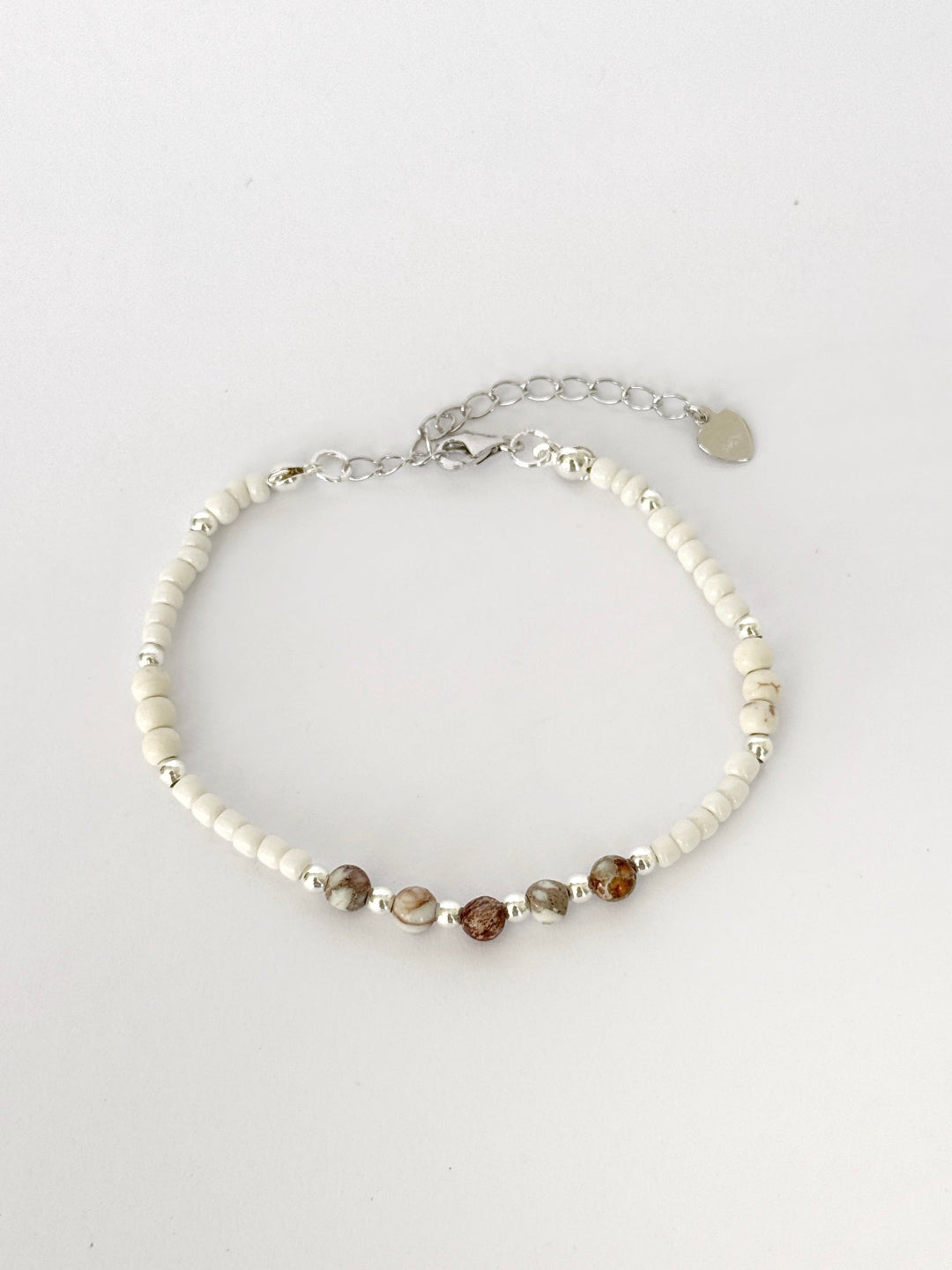 צמיד Pebble הוא צמיד חרוזים עדין בעבודת יד, בגווני לבן, קרם וחום טבעי שמזכירים חלוקי נחל קטנים. השילוב בין החרוזים הרכים לאלמנטים הכסופים יוצר מראה רגוע ונקי שמתאים לכל רגע ביום