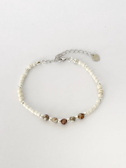 צמיד Pebble הוא צמיד חרוזים עדין בעבודת יד, בגווני לבן, קרם וחום טבעי שמזכירים חלוקי נחל קטנים. השילוב בין החרוזים הרכים לאלמנטים הכסופים יוצר מראה רגוע ונקי שמתאים לכל רגע ביום