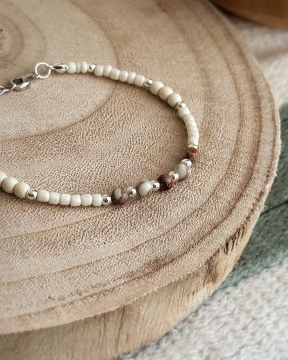 צמיד Pebble הוא צמיד חרוזים עדין בעבודת יד, בגווני לבן, קרם וחום טבעי שמזכירים חלוקי נחל קטנים. השילוב בין החרוזים הרכים לאלמנטים הכסופים יוצר מראה רגוע ונקי שמתאים לכל רגע ביום