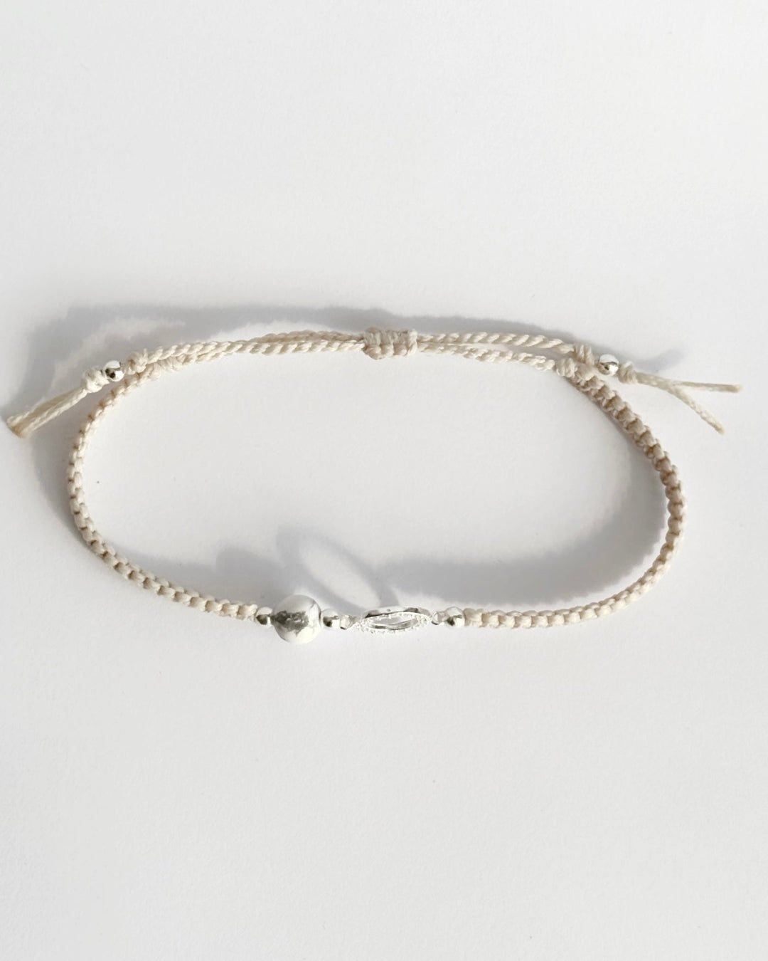 צמיד מקרמה עדין מדגם Halo, עם אלמנט עגול מצופה זרקונים ואבן Howlite לבנה, מצולם על רקע נקי