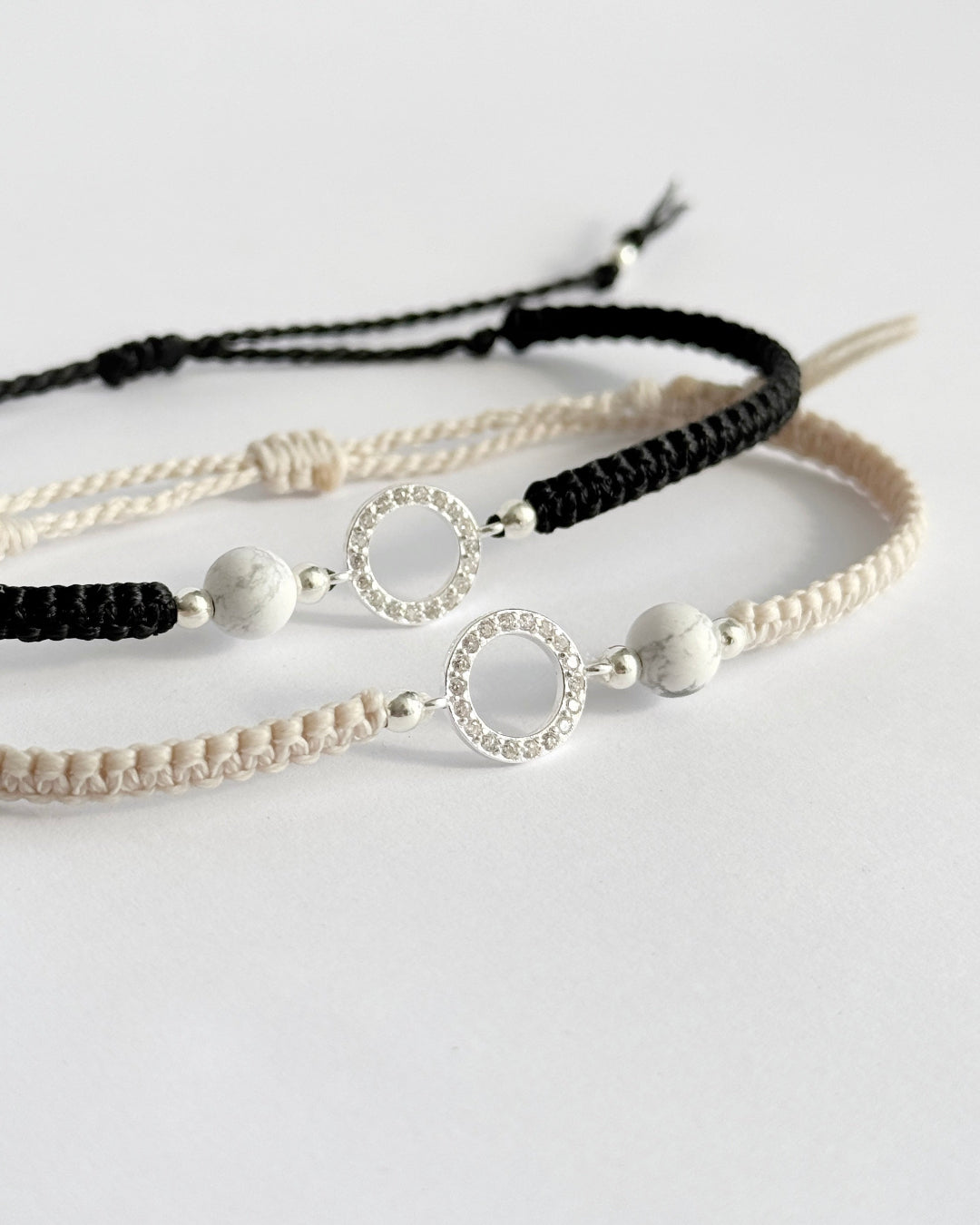 צמיד מקרמה עדין מדגם Halo, עם אלמנט עגול מצופה זרקונים ואבן Howlite לבנה, מצולם על רקע נקי