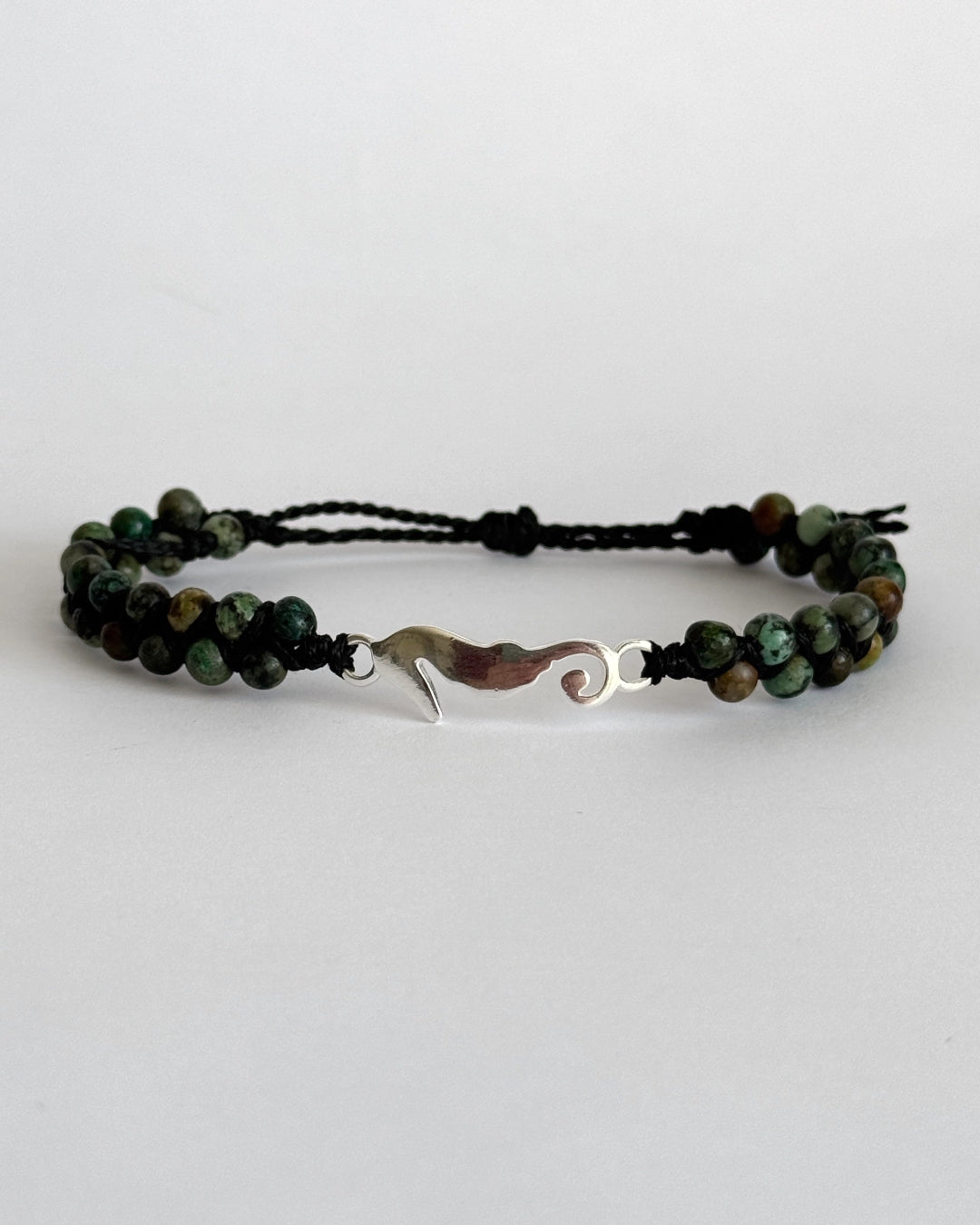 צמיד מקרמה Harbor בעבודת יד עם חרוזי טורקיז אפריקאי ותליון סוס ים מכסף 925 על רקע בהיר