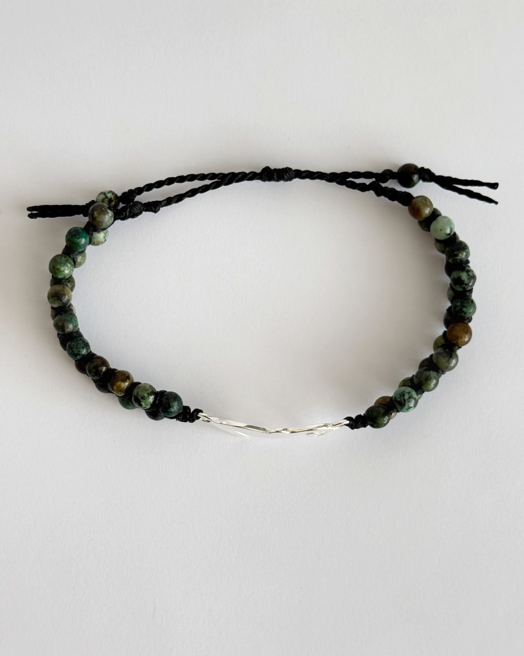 צמיד מקרמה Harbor בעבודת יד עם חרוזי טורקיז אפריקאי ותליון סוס ים מכסף 925 על רקע בהיר