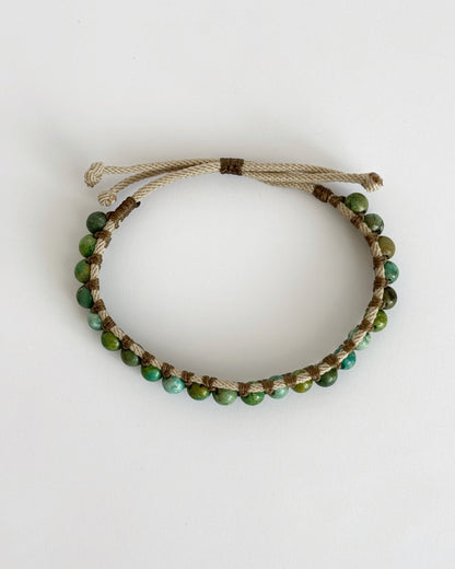 צמיד Creek בעבודת יד עם חרוזי טורקיז אפריקאי וחוטים טבעיים בגווני ירוק ומים על רקע בהיר