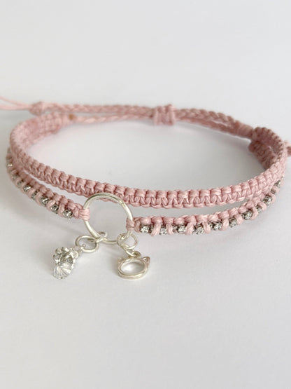 צמיד מקרמה כפול בגוון ורוד בייבי עם שרשרת זירקונים שזורה ותליוני כסף של חתול ופעמון - צמיד Stardust של Lala Fshasha.