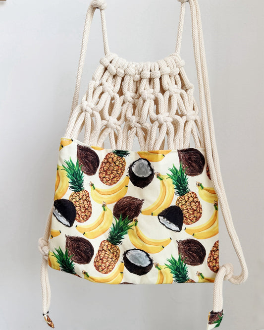 Handmade macramé backpack with soft cream macramé top and tropical fruit print canvas bottom in beige tones – Tropica Zanzibar design.